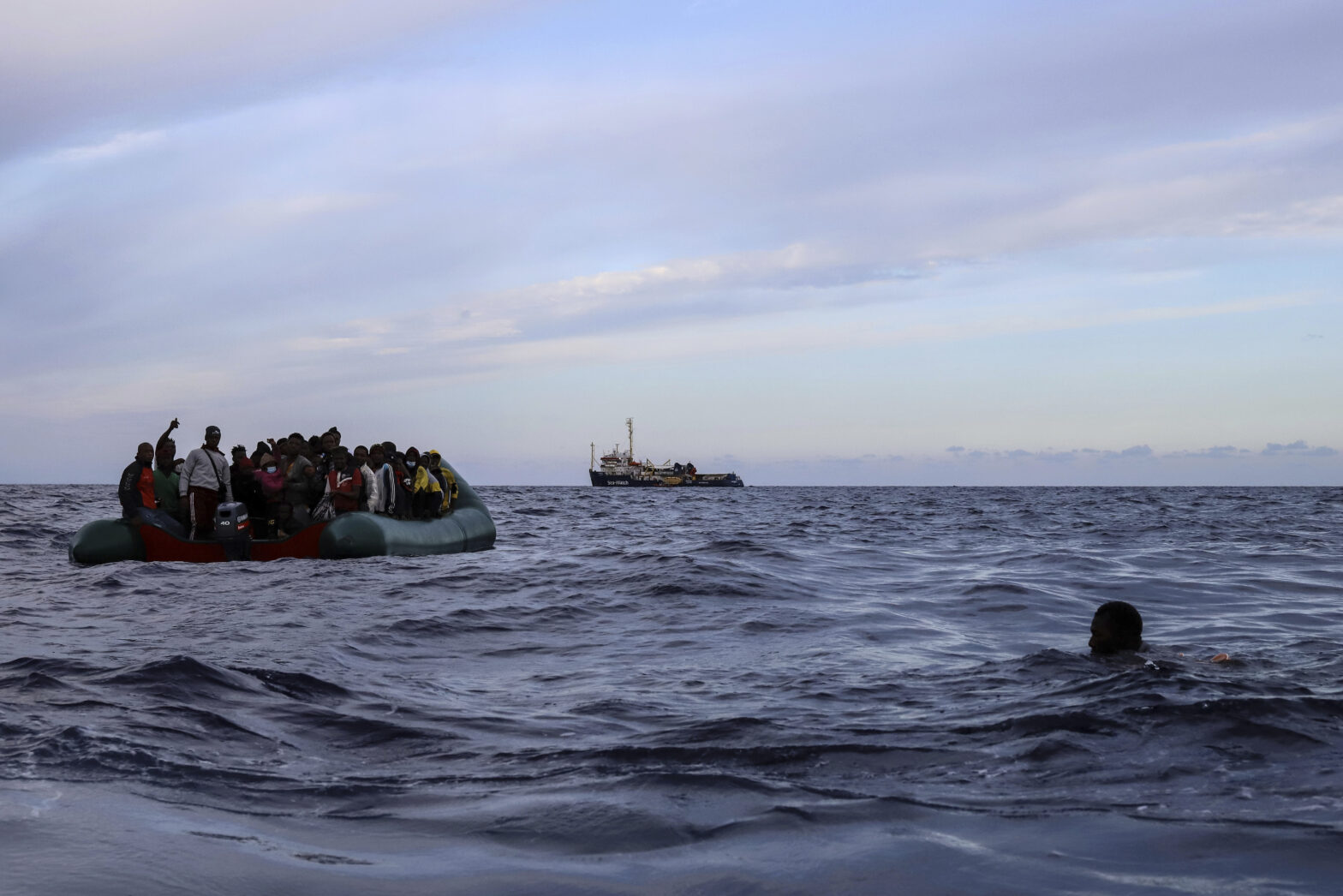 FILE - A migrant who was aboard a precarious rubber boat with others jumps to the water as they are rescued by a team of the Sea Watch-3, around 35 miles away from Libya, in Libyan SAR zone, Monday, Oct. 18, 2021. (AP Photo/Valeria Mongelli, File)